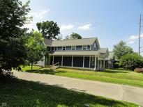 Charming home with inviting porch and well-maintained landscaping on a sunny day at 2502 N Harding St, Indianapolis, IN 46208