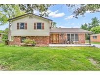 Charming two-story home featuring a well-manicured lawn and a covered front porch with rocking chairs at 2823 Tulip Dr, Indianapolis, IN 46227