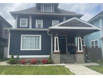 Charming two-story home with a covered front porch, neat landscaping, and a blue exterior at 3054 Ruckle St, Indianapolis, IN 46205