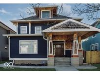 Beautiful two story home features a dark blue exterior, stone accents, covered porch, and well-maintained landscaping at 3054 Ruckle St, Indianapolis, IN 46205