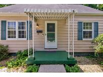Quaint front porch with a stylish awning, decorative columns, and vibrant green accents at 315 W 43Rd St, Indianapolis, IN 46208