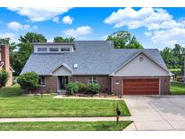 Beautiful brick home featuring an attached garage, mature landscaping, and a well-manicured lawn at 369 Rodeo Dr, Indianapolis, IN 46217