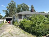 Charming ranch home with stone accents, mature trees, and a detached garage at 3709 N Layman Ave, Indianapolis, IN 46218