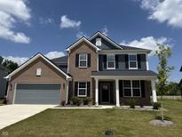 Charming two-story home featuring a brick and siding exterior with a well-manicured lawn at 614 Corbin Way, Avon, IN 46123