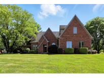 Charming brick home featuring well-maintained lawn and mature trees, offering a serene outdoor setting at 6183 Whitetail Run, Greenwood, IN 46143