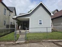 Charming bungalow featuring a gray exterior, covered porch and chain link fence at 624 Warren Ave, Indianapolis, IN 46221