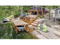 Beautiful lake house featuring a private boat dock, a wooden deck, and a wooded lot at 6497 Osprey Dr, Nineveh, IN 46164
