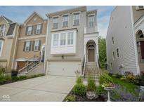 Charming townhome with a two-car garage, landscaped yard, and inviting front entrance and light colored brick at 692 Greenford N Trl, Carmel, IN 46032