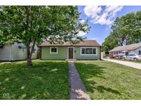 Charming single-story home with green exterior, well-maintained lawn, and inviting walkway at 710 S Bancroft St, Indianapolis, IN 46203