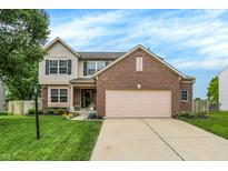 Charming two-story home featuring a brick facade, well-manicured lawn, and inviting curb appeal at 7215 Braxton Dr, Noblesville, IN 46062