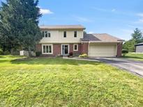 Charming two-story home with a brick facade, attached garage, and a lush green lawn, perfect for Gathering living at 757 Winter Way, Carmel, IN 46032