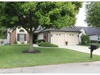 Charming home featuring a large tree, brick accents, and a well-maintained front lawn and two-car attached garage at 7662 Micawber Ct, Indianapolis, IN 46256
