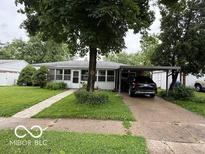 Charming single-story home featuring a covered carport and mature landscaping at 7918 Bonita Ct, Indianapolis, IN 46219