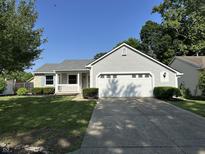 Charming home featuring a two-car garage, lush lawn, and inviting front porch on a sunny day at 952 Delray Dr, Indianapolis, IN 46241
