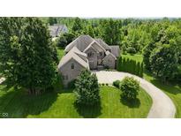 Beautiful brick home with a spacious driveway and mature trees creating a serene, private setting at 1008 Westcreek Dr, Columbus, IN 47201