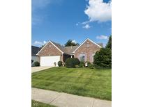 Charming brick home with a well-manicured lawn, flowering shrubs, and a two car garage at 10477 Silver Ridge Cir, Fishers, IN 46038
