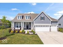 Charming two-story home with gray siding, white trim, and a covered front porch with a swing at 12078 Black Mill Pass, Fishers, IN 46040