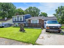 Split-level home showcasing a brick facade, blue siding, and a small deck in a well-maintained front yard at 1305 Gumwood Dr, Indianapolis, IN 46234