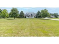 Traditional two-story home featuring a large front yard and a welcoming front porch at 1595 N 400 W, Greenfield, IN 46140