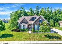 Charming brick home featuring beautiful landscaping, a well-manicured lawn, and inviting curb appeal at 1631 Caspian Dr, Carmel, IN 46032