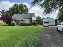 Charming brick home featuring a well-manicured lawn and an attached two-car garage at 2211 Rosedale Dr, Indianapolis, IN 46227