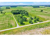 A serene aerial view of a countryside home surrounded by green fields and mature trees at 3001 W 226Th St, Sheridan, IN 46069