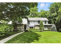 Beautiful home featuring a well-manicured front lawn, mature trees, and charming curb appeal at 380 Raintree Dr, Zionsville, IN 46077