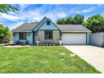 Charming home with stone accents, blue siding, inviting front yard, and a two-car garage at 5821 Pemberly Dr, Indianapolis, IN 46221