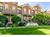 Attractive brick townhouse with a well-manicured lawn and lush landscaping at 6592 Reserve Dr, Indianapolis, IN 46220
