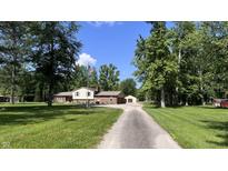 Charming two-story home with a brick facade, American flag, and a long gravel driveway at 6602 S 400 W, Columbus, IN 47201