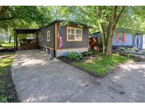Charming home featuring dark siding, bright orange trim, and well-maintained landscaping at 71 E Cove Ct, Cicero, IN 46034