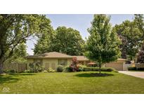 Charming ranch-style home featuring a well-manicured lawn and mature trees in a desirable neighborhood at 7401 N Layman Ave, Indianapolis, IN 46250