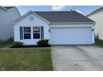 Charming single-story home featuring a well-manicured lawn, two-car garage, and classic architectural details at 10891 Sweetsen Rd, Camby, IN 46113
