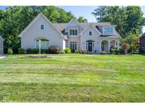 Elegant two-story white brick home with well-manicured lawn and mature trees, showcasing classic curb appeal at 11350 Old Stone Dr, Indianapolis, IN 46236