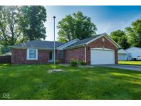 Charming brick home with a well-manicured lawn and attached two car garage at 12113 N Rooker Rd, Mooresville, IN 46158
