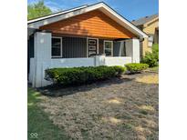 Charming front porch with freshly painted white brick and dark siding and a wood plank ceiling at 2543 Union St, Indianapolis, IN 46225