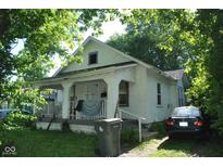 Charming two-story home with a covered porch and lush greenery surrounding the property at 3443 N Chester Ave, Indianapolis, IN 46218