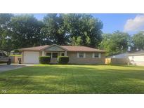 Charming single-story home with well-manicured lawn, stone facade, and attached garage at 4614 Runyon Lake W Dr, Greenwood, IN 46143