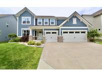 Charming two-story home with a two car garage, landscaped yard, and light blue siding at 5473 Forest Glen Dr, Brownsburg, IN 46112