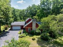 Charming two-story home with a stone chimney, attached garage, and professionally landscaped yard at 5631 Shelby St, Indianapolis, IN 46227