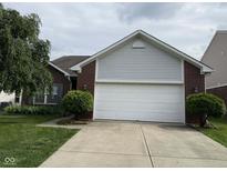 Charming brick home featuring an attached two-car garage and well-maintained landscaping at 621 Appleseed Way, Indianapolis, IN 46217