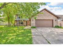 Charming two-story brick home featuring an attached two car garage and lovely front lawn at 6329 Whitaker Farms Dr, Indianapolis, IN 46237