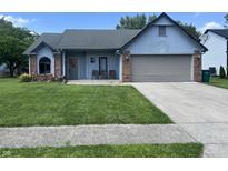 Charming one-story home with a well-manicured lawn, attached garage, and inviting front porch at 6932 Deerbrook Ct, Indianapolis, IN 46214