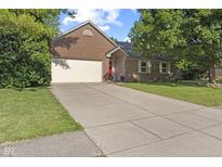 Brick home with a two-car garage, manicured lawn and long driveway at 7239 N Orchard Dr, Indianapolis, IN 46236