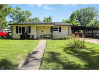Charming single-story home with a well-maintained lawn, covered parking, and inviting front porch at 7307 Twin Beech Dr, Indianapolis, IN 46226