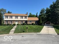 Charming two-story home featuring a well-maintained lawn and inviting curb appeal at 7334 Fairwood Cir, Indianapolis, IN 46256