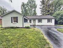 Charming single-story home with a freshly painted white exterior and inviting curb appeal in a well-maintained yard at 7719 Grandview Dr, Indianapolis, IN 46260