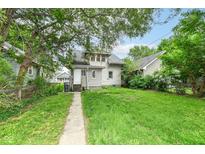 Cozy home boasts a spacious backyard with a long concrete walkway and lush greenery at 806 N Gray St, Indianapolis, IN 46201