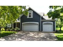 Charming two-story home with a two-car garage and lush landscaping, complete with mature trees at 8394 Glen Highlands Dr, Indianapolis, IN 46236