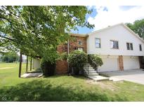 Charming townhome featuring brick and siding, complemented by a well-maintained lawn and mature trees at 9323 Doubloon Rd, Indianapolis, IN 46268
